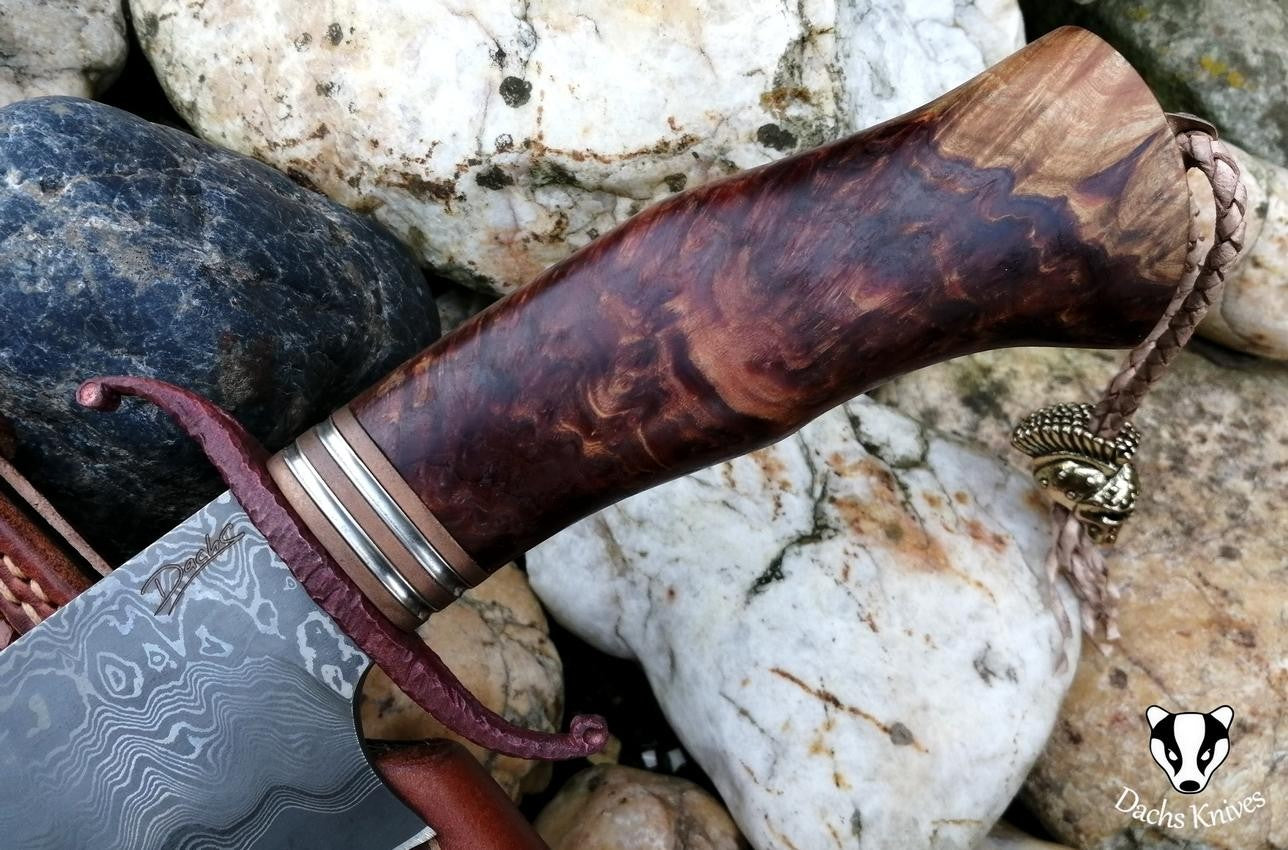 Ergonomická rukojeť nože s kovovými detaily, detailní záběr.
