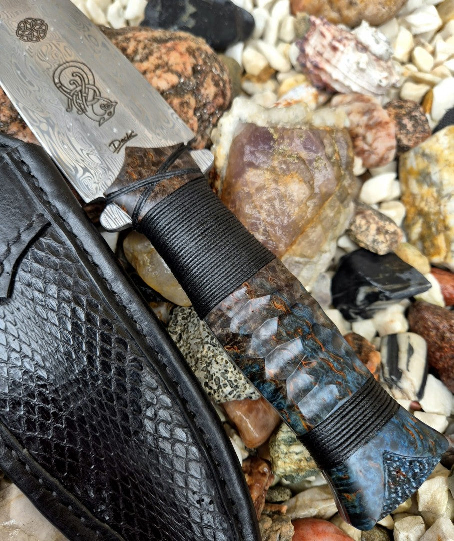 Detail rukojeti s výraznou strukturou a damaškové čepele v kombinaci s elegantním pouzdrem z hadí kůže