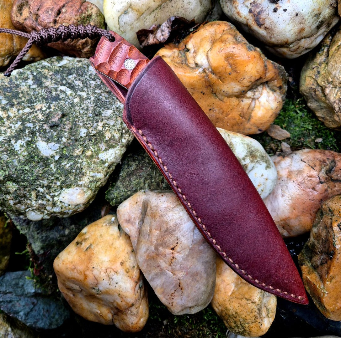 Ručně vyrobený outdoorový nůž s čepelí z nerezové oceli a ergonomickou rukojetí z exotického dřeva, doplněný koženým pouzdrem – ideální pro bushcraft, kempování a survival aktivity.
