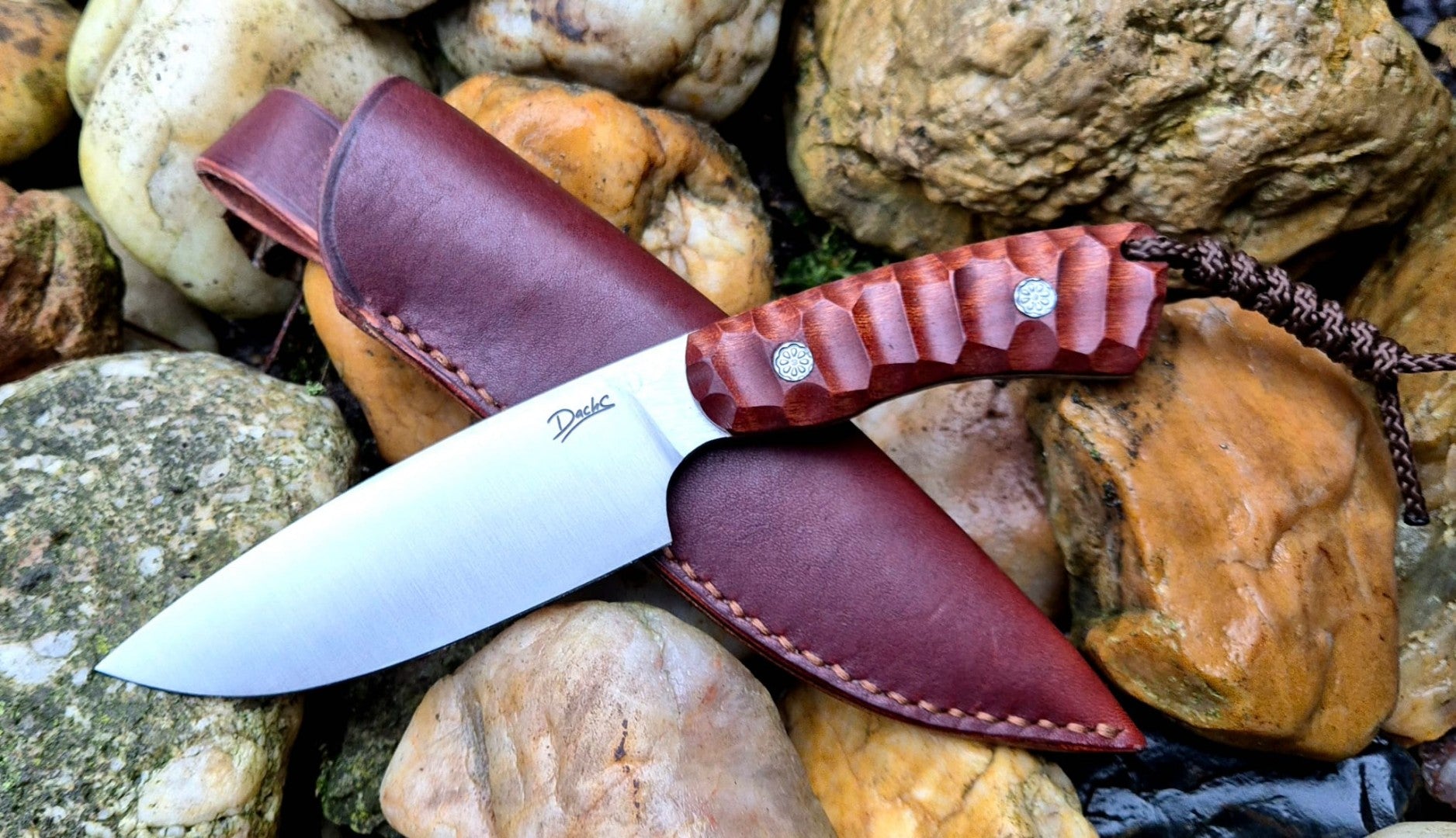 Ručně vyrobený outdoorový nůž s čepelí z nerezové oceli a ergonomickou rukojetí z exotického dřeva, doplněný koženým pouzdrem – ideální pro bushcraft, kempování a survival aktivity.