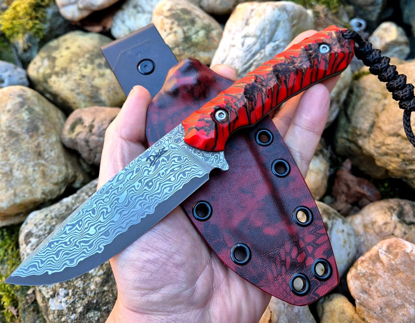 Ručně vyrobený damaškový nůž s výraznou rukojetí z červeného šišky v pryskyřici a Kydex pouzdrem – ideální lovecký, bushcraft a EDC nůž pro outdoor nadšence. Nerezová damašková čepel s unikátním vzorem, ergonomický úchop a odolné pouzdro vhodné na opasek