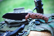 Armádní a lovecký nůž ARES III s hnědou rukojetí položený na výstroji v přírodě